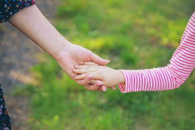 A child with his mother goes by the hand. Selective focus.