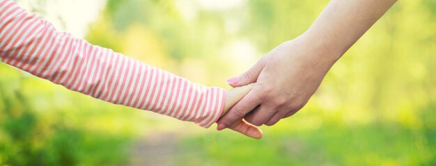 Un bambino con sua madre passa per mano