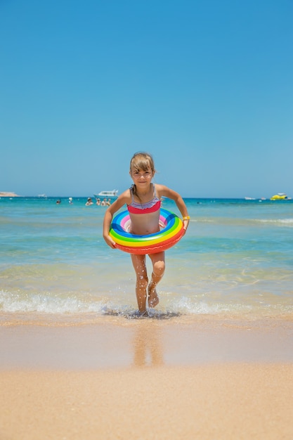 海で救命浮き輪を持つ子供