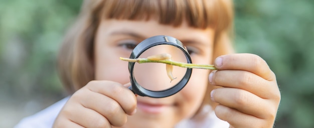 彼の手に虫眼鏡を持つ子供