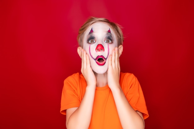 Photo child with makeup, then halloween grabbed his face with both hands in amazement and fear.