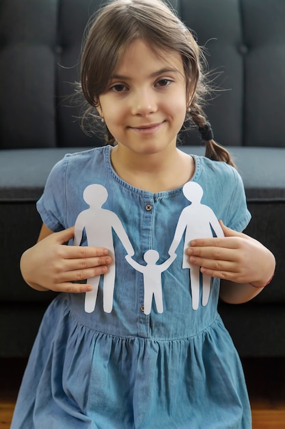 Child with a paper family in his hands.