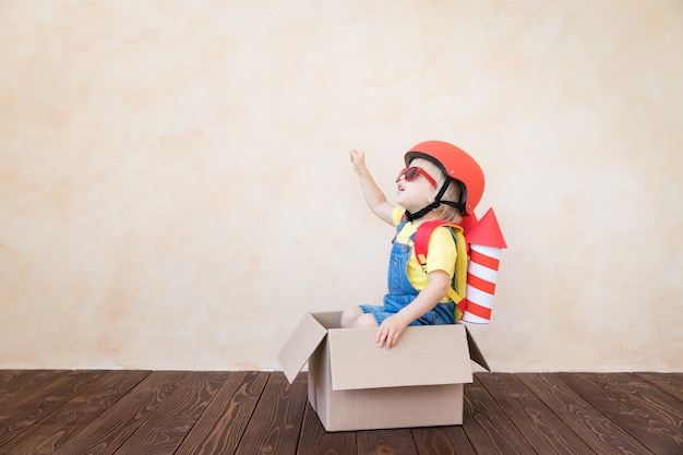 Child with paper rocket playing indoor