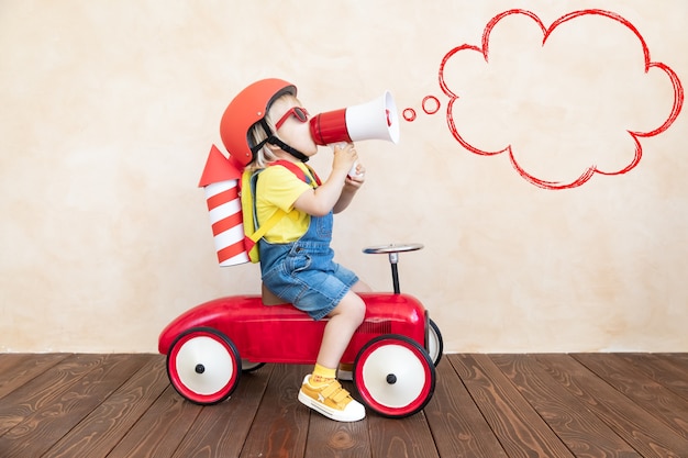 Child with paper rocket playing indoor