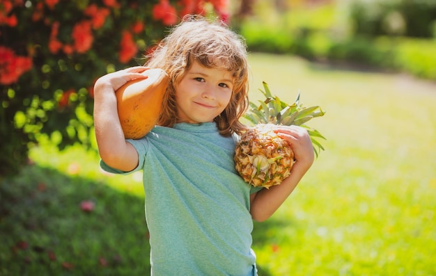 Child with pineapple and coconut at yard Kids summer vitamin Tropical fruits