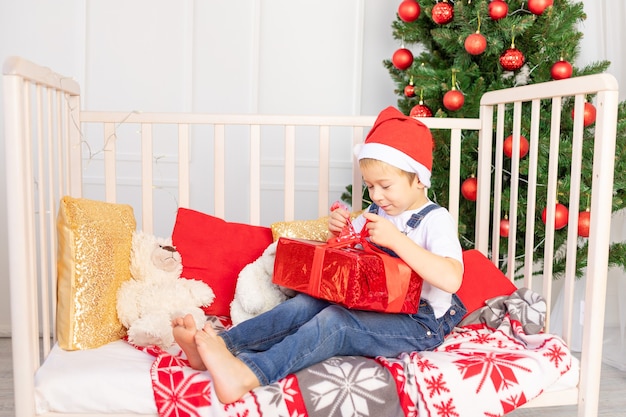 A child with a santa hat is sitting in a children room