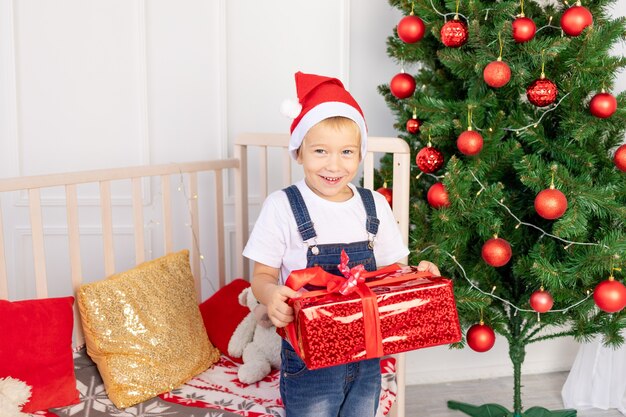 A child with a santa hat is sitting in a children room