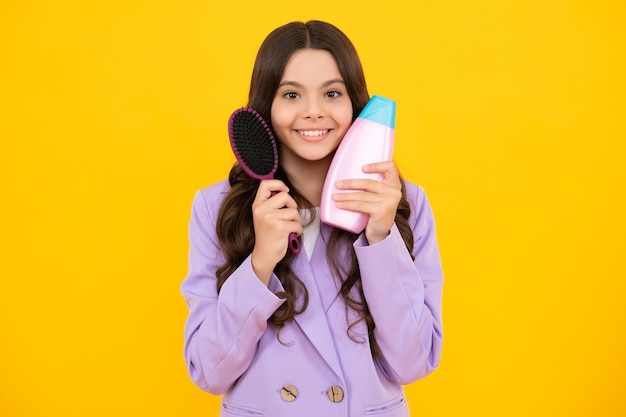 Child with shampoo conditioner Daily cosmetic care Teenager kid 12 13 14 years old hold bottle of hair and skin care Beauty health and cosmetics Happy face positive and smiling