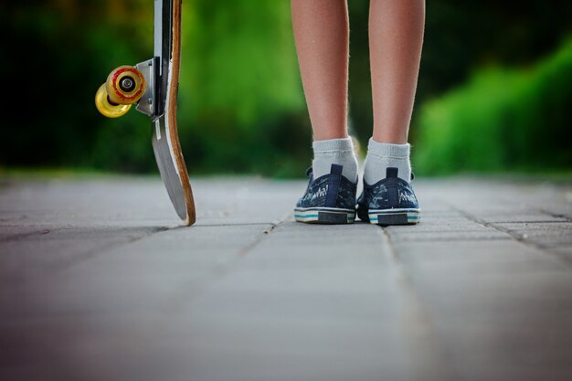 Child with skateboard on the street in sunny day