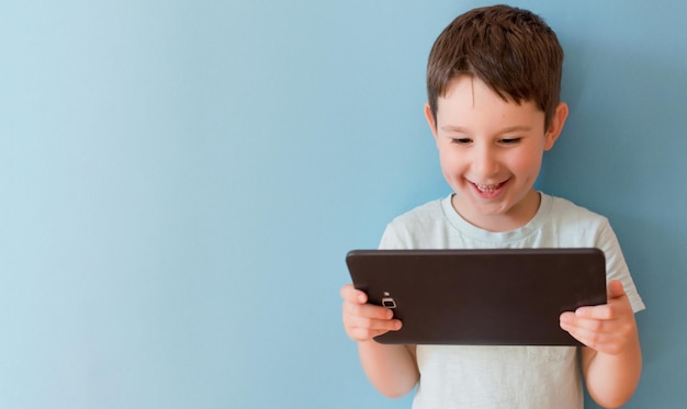 Photo child with tablet on blue background