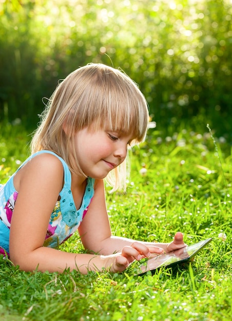 야외에서 태블릿 컴퓨터를 사용하는 어린이