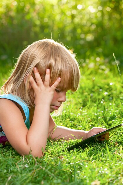 Photo child with a tablet computer outdoor