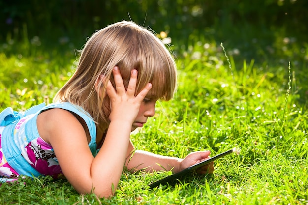 Child with a tablet computer outdoor