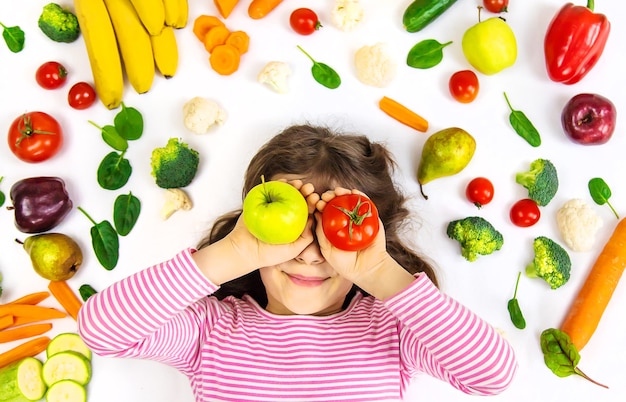 Ребенок с овощами и фруктами в руках