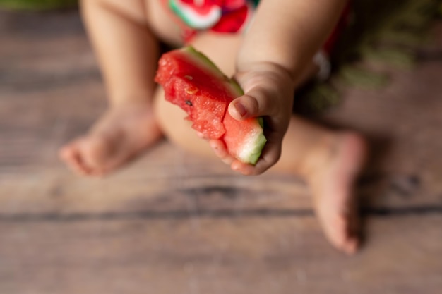 スイカを持つ子供。金髪の少女がスイカを食べる。健康的な新鮮なビタミン スイカ