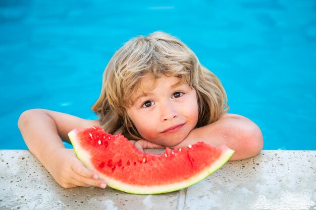 Child with watermelon in pool outdoor Kid having fun in swimming pool Kids summer vacation and healt