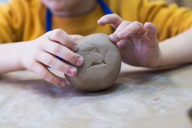 Foto il bambino lavora con l'argilla