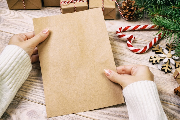 Il bambino scrive le lettere e le tiene in mani su superficie di legno d'annata rustica