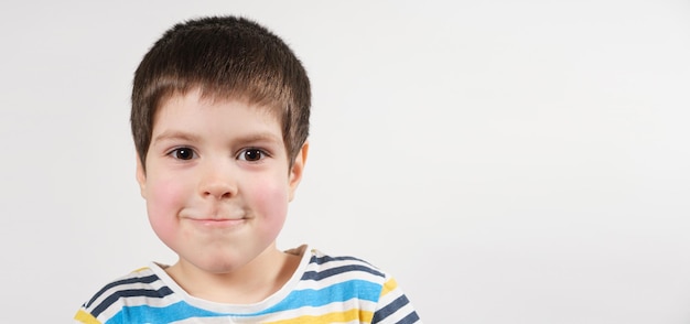 A child of years old with red cheeks looks into the camera