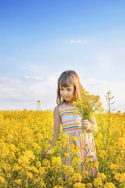 Un bambino in un campo giallo, fiori di senape