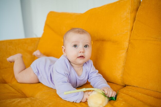 Photo child on a yellow sofa with flowers at home high quality photo