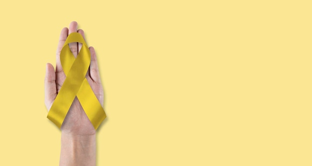 Photo childhood cancer awareness with gold ribbon isolated on white background with clipping path golden bow color for embryonal rhabdomyosarcoma