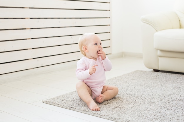 子供の頃と子供のコンセプト-床に座っているかわいい魅力的な赤ちゃん