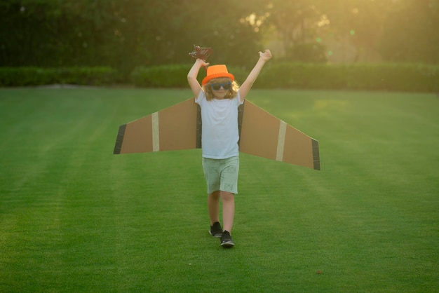 시골에 어린 시절 여름 필드 여행 야외에서 장난감 종이 날개를 가지고 노는 행복한 아이