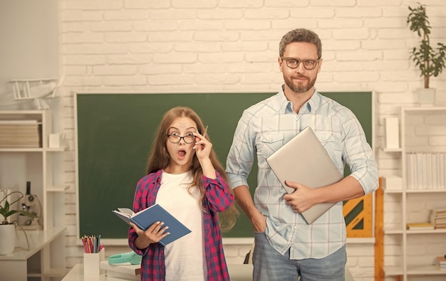 Photo childhood education amazed pupil and tutor with computer father and teen girl study