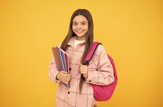 Childhood and education cheerful student hold notebooks and books back to school teen girl in checkered shirt happy kid casual style carry backpack tween child with school bag