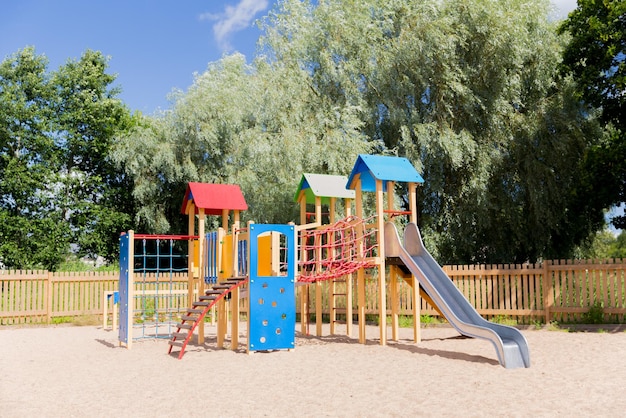 childhood, equipment and object concept - climbing frame with slide on playground outdoors at summer