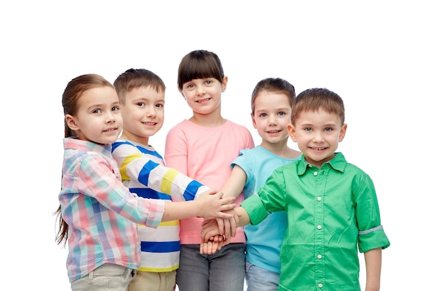 childhood, fashion, friendship and people concept - happy little children with hands on top