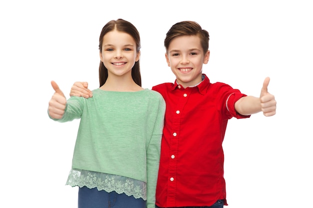 childhood, fashion, gesture and people concept - happy smiling boy and girl hugging and showing thumbs up