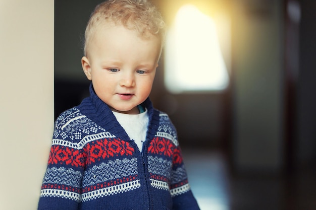 Childhood fun and people concept happy little boy behind door at home