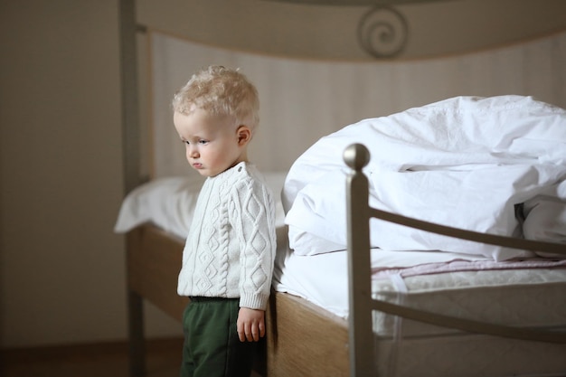 Childhood fun and people concept happy little boy behind door at home