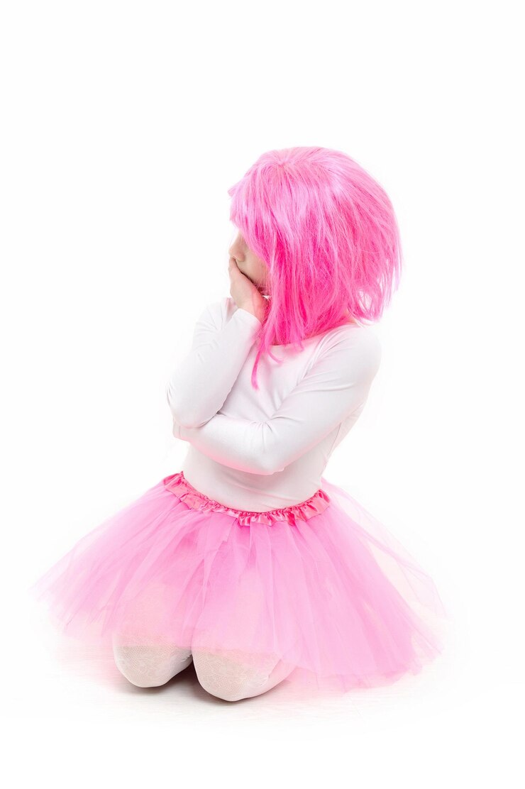 Photo childhood and happiness. child in wig isolated on white background. beauty and fashion. small girl t in pink skirt. ballet and art.