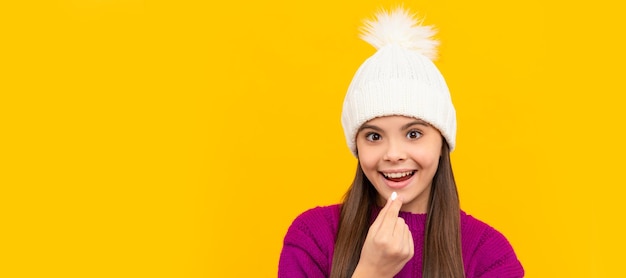 Foto salute infantile bambino in cappello invernale che prende integratore alimentare pillola poster orizzontale dello spazio di copia dell'intestazione del banner del viso del bambino isolato