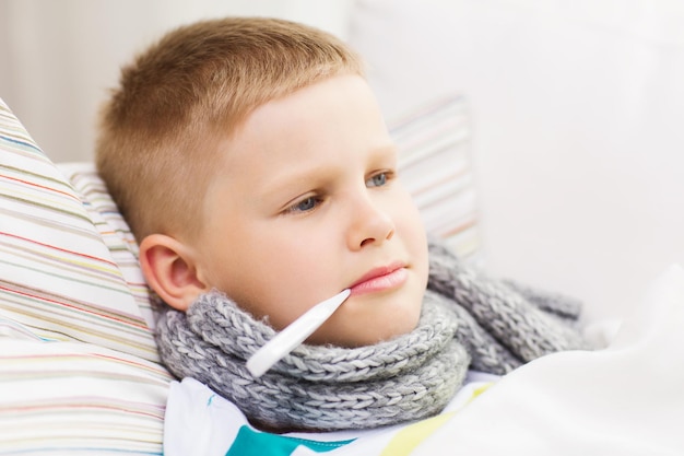 childhood, healthcare and medicine concept - ill boy with flu at home