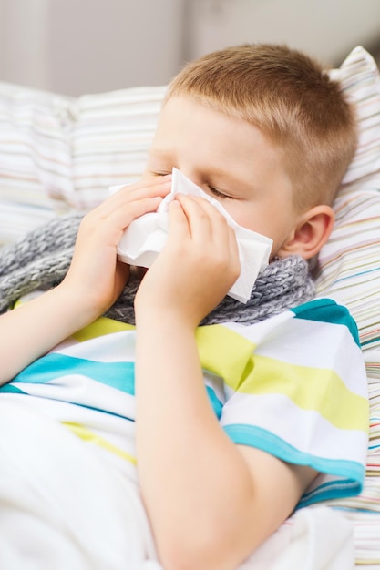 childhood, healthcare and medicine concept - ill boy with flu at home