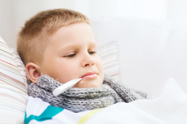 Foto concetto di infanzia, assistenza sanitaria e medicina - ragazzo malato con influenza a casa