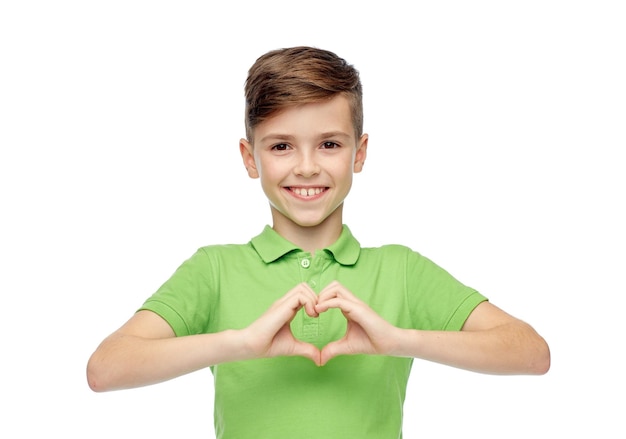 유년기, 사랑, 자선, 건강 관리 및 사람 개념 - 심장 손 기호를 보여주는 녹색 폴로 티셔츠를 입은 행복한 웃는 소년