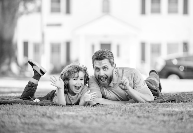 Childhood and parenthood parent relax with little child boy on grass dad with kid