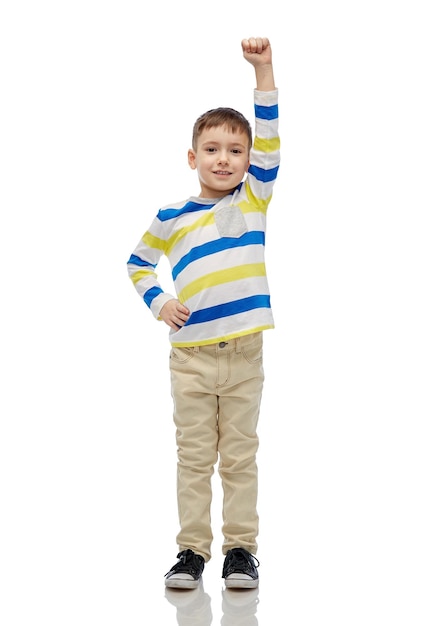 childhood, power, gesture and people concept - happy smiling little boy with raised hand