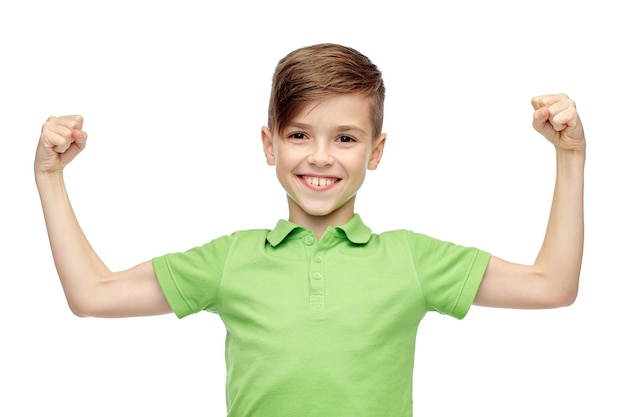 childhood, power, strength and people concept - happy smiling boy in green polo t-shirt showing strong fists