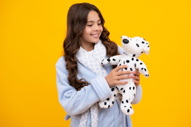 Childhood toys and kids Child in pajamas good morning Cute teen girl cuddling fluffy toy