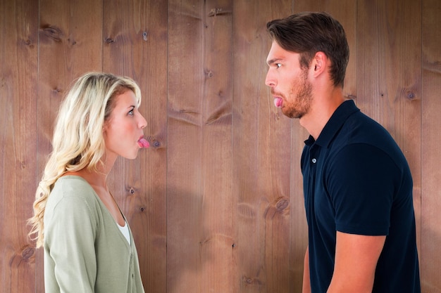 Photo childish couple having an argument against wooden planks