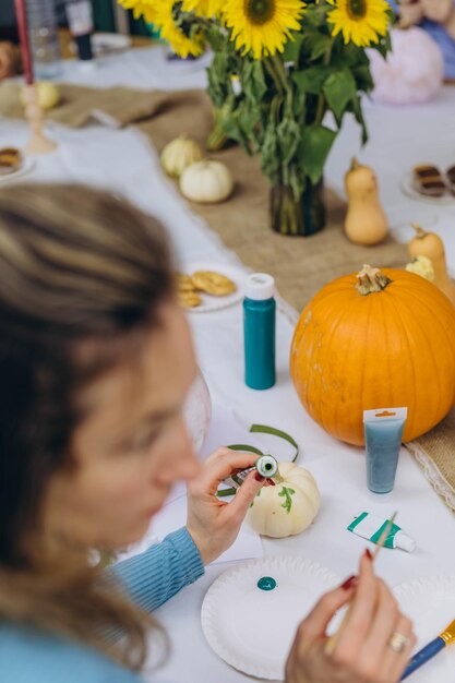 children and adults painting pumpkins for halloween enjoying a fun and creative activity together