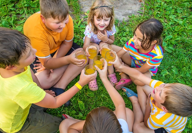 子供たちは一緒に路上でレモネードを飲んでいます。