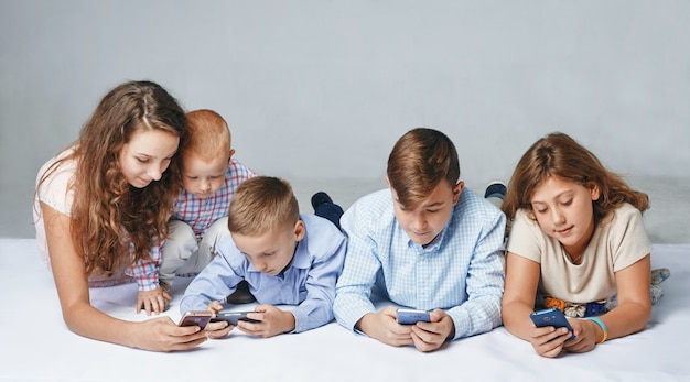 Дети сосредоточены на игре в смартфоны