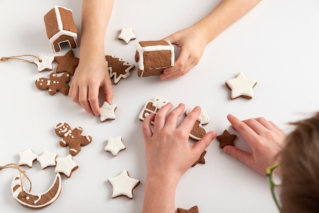 Children are getting ready for Christmas. Gingerbread cookies in children's hands. Top view.